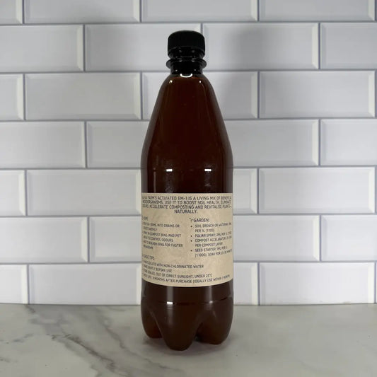 Bottle with a label detailing the uses of EM-1 on a tiled wall background