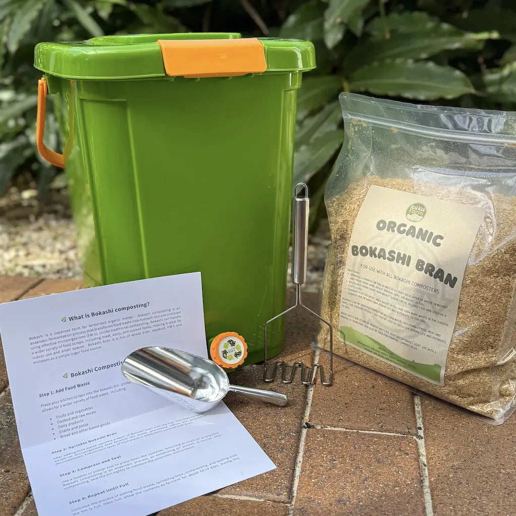 Green 20L compost bin with orange handle, organic bokashi bran package, scoop, fork, and educational instructions.