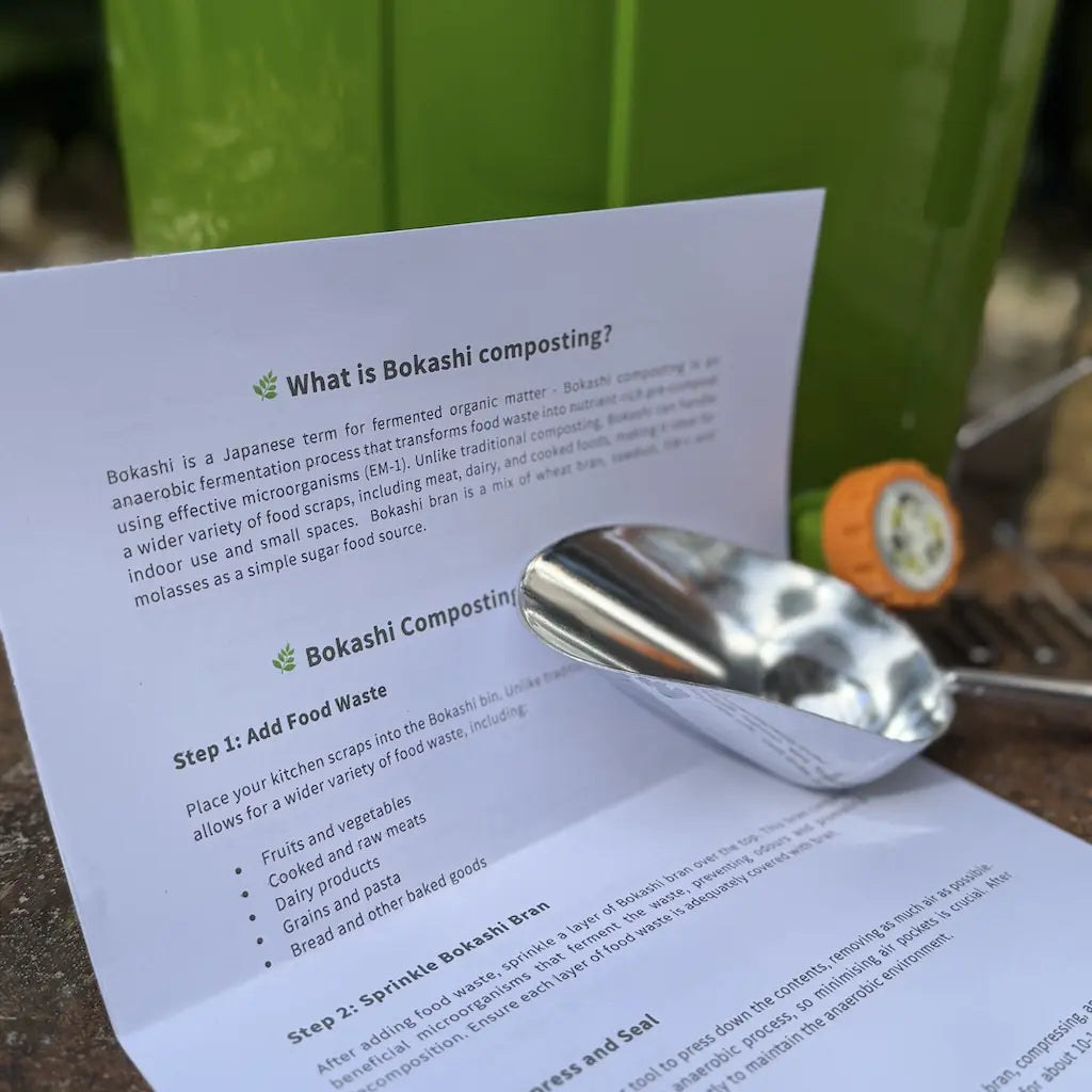Sheet of paper with text about bokashi composting, a metal scoop next to a bokashi bin