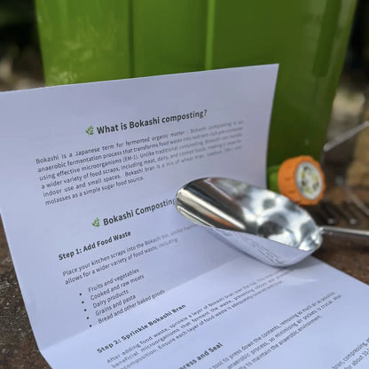 Sheet of paper with text about bokashi composting, a metal scoop next to a bokashi bin