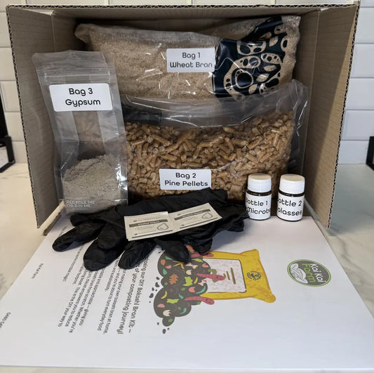 Box containing DIY Bokashi bran kit supplies including bags of wheat bran, pine pellets, and bottles containing 'EM-1 Microbes' and 'Molasses'.