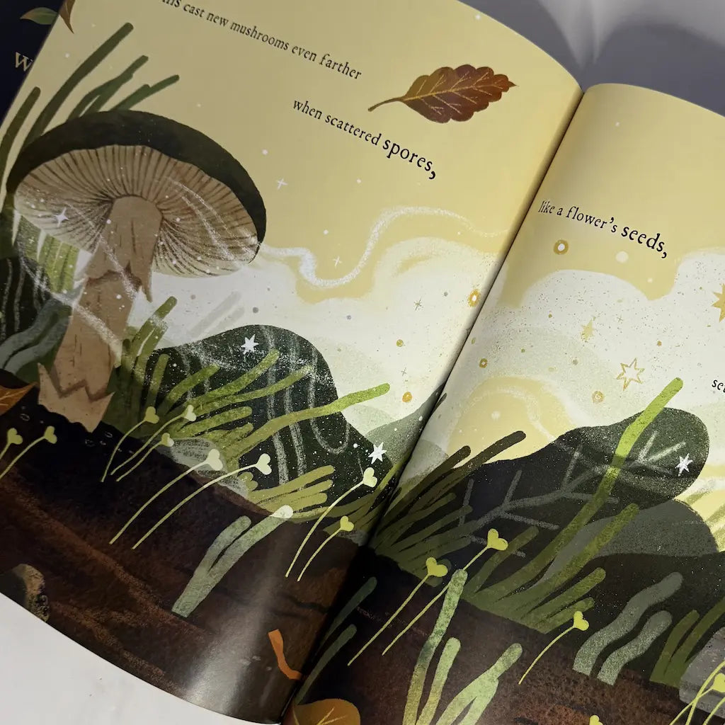 Illustrated book open to a page with mushrooms and foliage