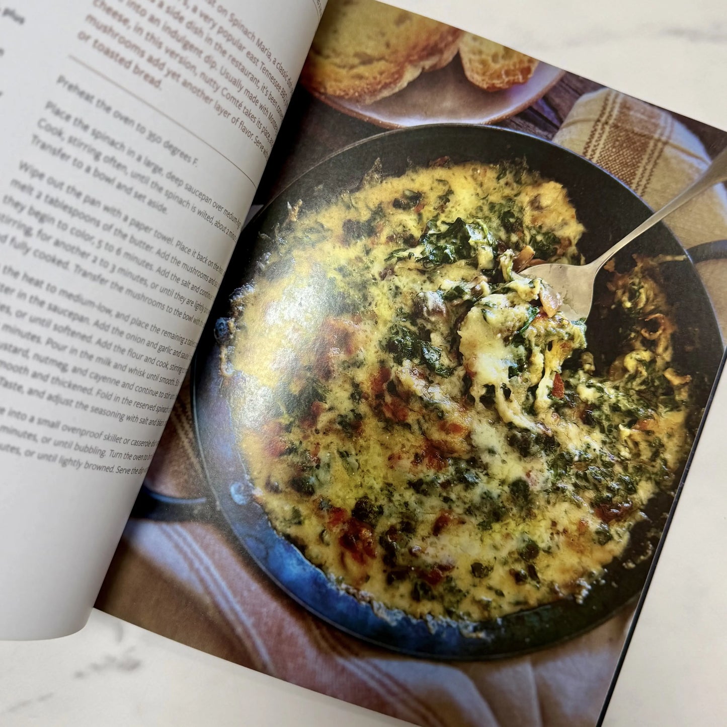 Open cookbook showing a dish with a fork in it
