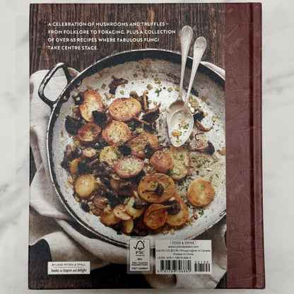 Cookbook cover with a dish of potatoes and mushrooms on a wooden surface
