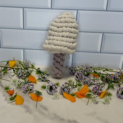 Textured mushroom-shaped object on a tiled floor with flowers and leaves.