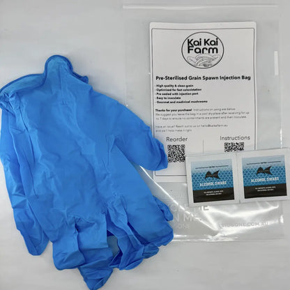 A grain spawn injection bag kit by Kai Kai Farm, featuring a pair of blue nitrile gloves, a pre-sterilised injection bag with printed instructions, and two small IPA swab packets.